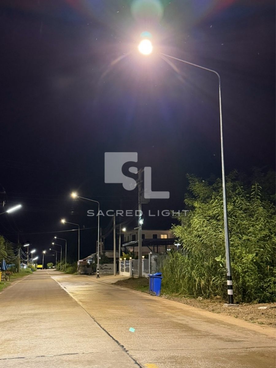 โค้งถนน นว.ถ-00096 มีรั้วบ้านข้างทาง แสงสว่างต่อเนื่องจากโคมไฟ LED อบจ.นครสวรรค์